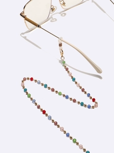 Detail of colorful faceted crystal beaded eyewear chain with gold clips and silicone loops