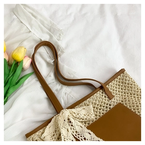 Close-up of beige woven tote bag with white lace bow and brown leather pocket detail