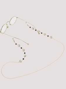Detail of gold glasses chain with black and white beads and silicone anti-slip ends