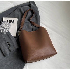 Close-up of brown litchi pattern tote with golden buckle on professional business background