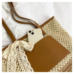 Detail of hand-woven straw tote with large lace bow and brown leather phone pocket