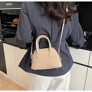Detailed view of apricot seashell bag showing pebble texture and adjustable shoulder strap