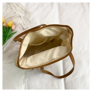 Detailed top view of handmade straw tote bag showing spacious interior with zipper closure
