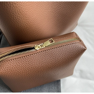 Detail of brown litchi pattern leather tote with premium golden zipper hardware