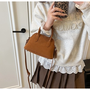 Brown lychee leather shell handbag styled with white pearl hoodie and pleated skirt