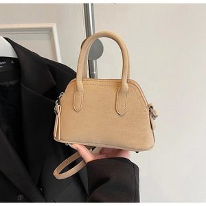 Detail of light beige grained leather mini bag with dual handles and tassel zipper decor