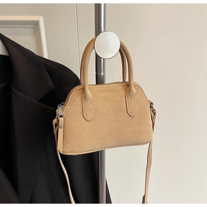 Detail of beige lychee pattern shell bag with silver hardware and top dual zippers