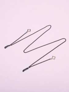 Detail of black glasses chain with golden square charms and rubber loop connectors