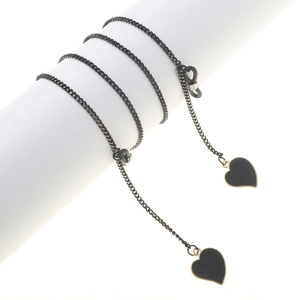 Minimalist black glasses chain with heart pendants and golden metal links on white display