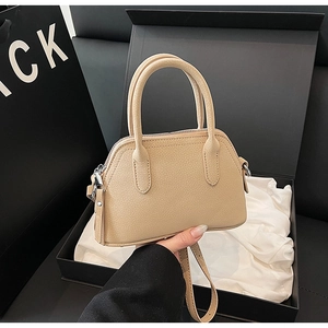 Close-up of beige litchi grain leather bag with silver hardware in premium gift packaging