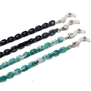 Detail of chunky acrylic eyewear chains in black and marble green with metal lobster clasps