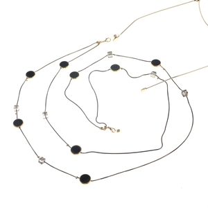 Detailansicht einer dualen Brillenkette in Gold mit schwarzen Discs und Kristallen