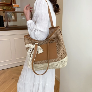 Handwoven straw tote bag with brown leather pockets and lace bow for summer beach vacations