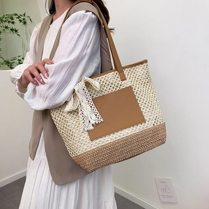 Handwoven straw tote bag with brown leather patch and white lace bow decoration
