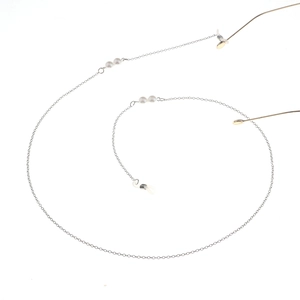 Détail de chaîne de lunettes argentée avec perles blanches et boucles silicone