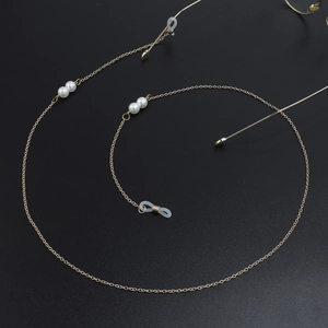 Détail de chaîne à lunettes dorée avec perles et boucles antidérapantes sur fond noir