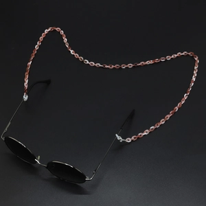 Macro shot of marble textured acrylic glasses chain with silver metal buckles on black