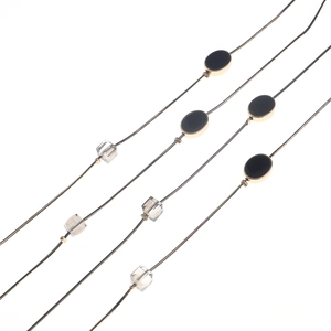 Detail van de multifunctionele zwarte kristallen ketting met bronskleurige bedels