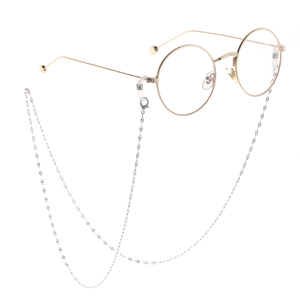 Lunettes rondes rétro dorées avec chaîne en métal argenté sur fond blanc pur