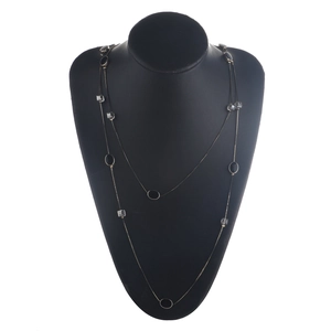 Dubbellaagse gouden ketting met zwarte ovale bedeltjes en kristallen hangers