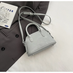 Detail of light gray pebbled leather mini Boston bag with silver hardware and bottom studs