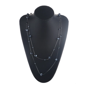 Detail of a double-layer long necklace with dark grey crystal beads and silver chain link