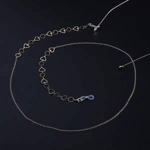 Chaîne de lunettes dorée élégante avec cœurs et embouts en silicone sur fond noir