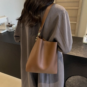 Brown textured leather bucket tote bag for women showing a minimalist shoulder style