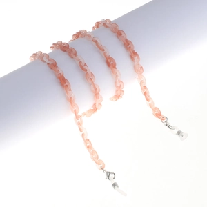 Detailed macro view of amber texture resin eyewear chain with white silicone loops