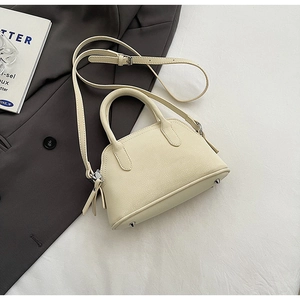 Detailed macro view of cream litchi texture synthetic leather on a crossbody bag