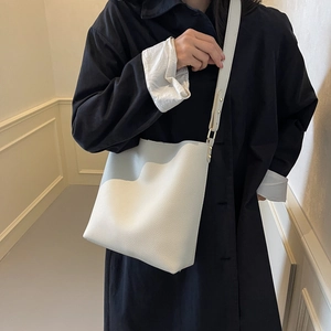 Chic beige lychee leather bucket bag with wide strap for stylish commuter women