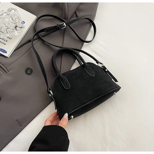 Close-up of black lychee grain leather mini bag with silver studs and top handles