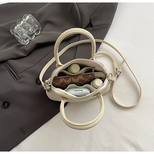 Interior view showing main compartment with zipper pockets of off-white crossbody bag