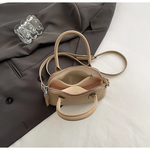 Top-down view of the beige shell bag interior showing zip compartments and pebbled texture