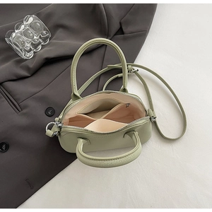 Top view of sage green mini bag showing zippered compartments and interior lining details