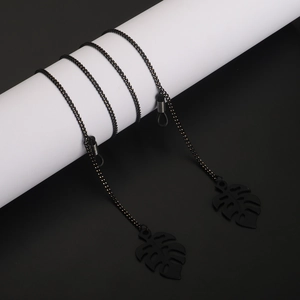 Matte black glasses chain featuring minimalist hollow monstera leaf pendants for fashion