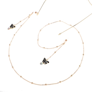 Detail of golden glasses chain featuring elegant black and white butterfly charms and pearls