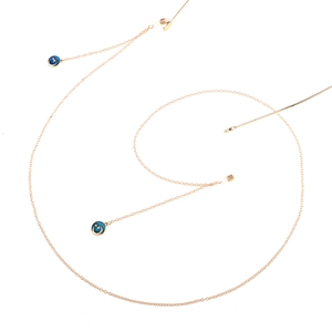 Golden eyewear chain with blue enamel star and moon charms on white background