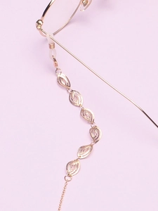Detail of gold hollow leaf eyeglass chain with silicone loops on light background