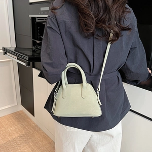 Minimalist light green shell handbag with crossbody strap and pebble leather texture