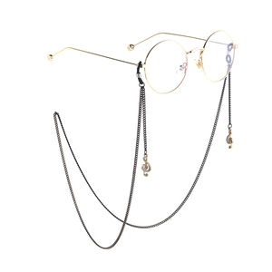 Runde goldene Metallbrille mit schwarzen Ketten und musikalischen Notenanhängern