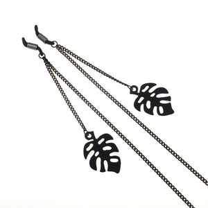 Fashionable black eyewear chain with hollow monstera leaf pendants and silicone loops
