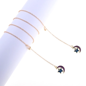 Goldene Brillenkette mit blauem Stern und lila Mond Anhänger auf weißem Ständer