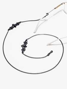 Détail du pendentif chauve-souris évidé et boucle en caoutchouc sur chaîne de lunettes