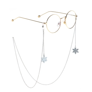 Golden metal round glasses with snowflake pendant eyeglass chain on white background