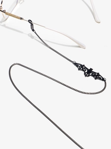 Détail de la chaîne de lunettes en métal noir avec pendentif chauve-souris ajouré