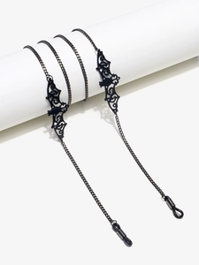 Détail de la chaîne de lunettes noire en métal avec pendentifs chauve-souris ajourés gothiques