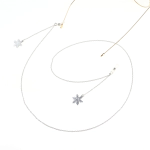 Detail of silver eyewear chain with snowflake charms and anti-slip silicone loops