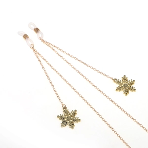 Detailed shot of golden eyewear chain featuring hollow snowflake charms and anti-slip loops