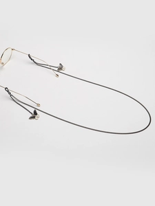 Detail of delicate black metal glasses chain with white and black enamel butterfly charms